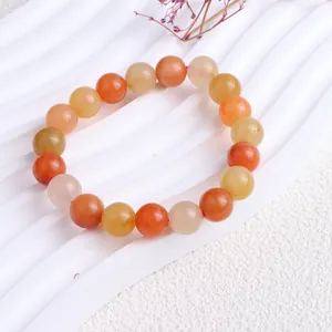 Nahaufnahme eines natürlichen Jinsiyu-Steinperlenarmbandes mit orangen und gelben Jadeperlen
