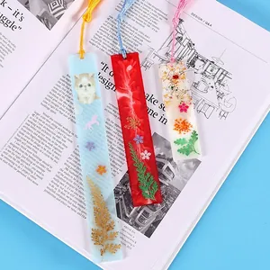 Set aus handgefertigten DIY-Harz-Lesezeichen mit Trockenblumen und bunten Quasten.