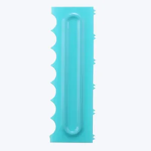 Detail view of a turquoise plastic cake scraper with serrated edges for baking designs
