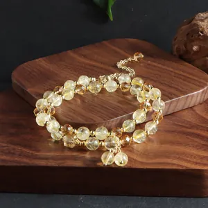 Macro detail of natural citrine double-strand bracelet featuring golden tassels and beads
