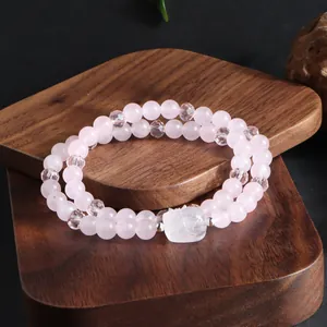 Gros plan d'un bracelet double rang en quartz rose naturel et perles de cristal.