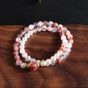 Macro detailed view of an elegant double-strand bracelet with pearls and red included quartz