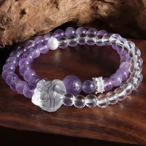 Gros plan détaillé d'un bracelet en améthyste et cristal avec lion sculpté à la main.