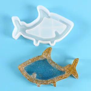 Gedetailleerd overzicht van een haaienvormige siliconen mal met een goud en blauw glitterharsmonster