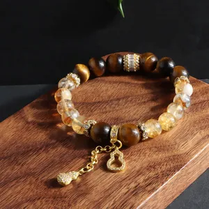 Detailed view of a natural tiger eye and yellow crystal bracelet with diamond gourd charms.