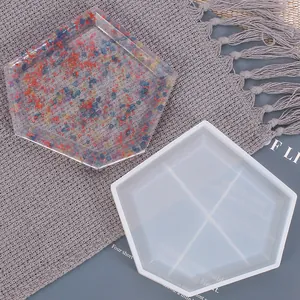 Vista detallada de un molde de silicona hexagonal y una bandeja de resina con virutas de colores