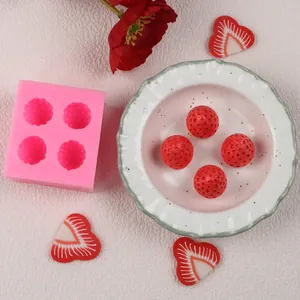 Vue détaillée du moule en silicone rose avec des boules de fraise texturées pour gâteaux