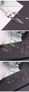 Detailansicht eleganter langer Quastenohrringe mit realistischen Zikadenflügeln und Perlen.
