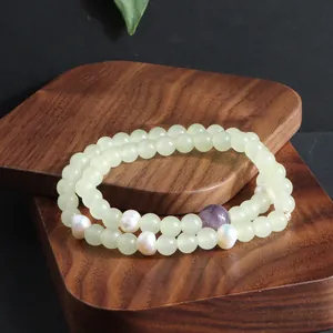 Detail van dubbellaagse armband met Tianshan jade, zoetwaterparels en amethist.