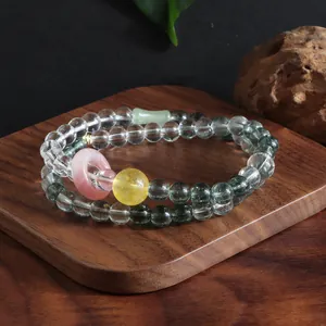 Close-up of a double-strand gemstone bracelet featuring citrine, rose quartz and phantom quartz