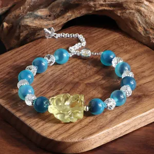 Detailansicht eines blauen Achat- und Kristallarmbands mit gelber Fuchs-Schnitzerei.