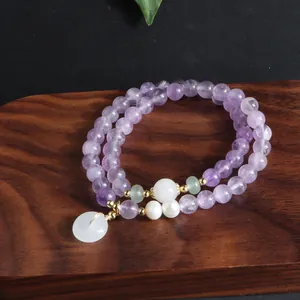Detailansicht eines zweilagigen Amethyst-Armbands mit edlem weißen Jade-Anhänger