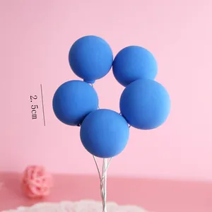 Detailed view of 2.5cm blue clay balloon cake toppers on silver wire stems for baking