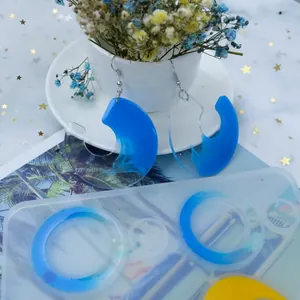 Vue détaillée du moule en silicone et des boucles d'oreilles géométriques en résine bleue