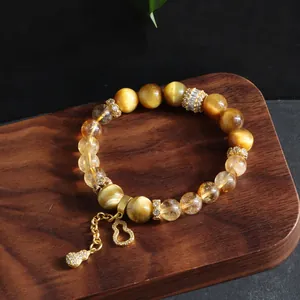 Detailed view of natural golden tiger eye and yellow crystal bracelet with lucky gourd charm