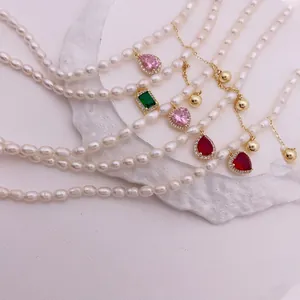 Élégant collier en perles d'eau douce avec pendentifs en zircon et pompons dorés