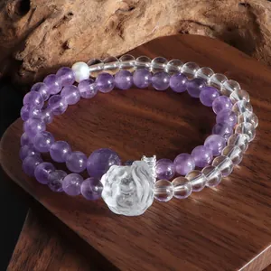 Détail exquis d'un bracelet double couche en améthyste et quartz avec breloque lion sculpté.