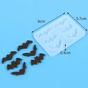 Bat-shaped silicone mold with finished resin bats and dimension markings