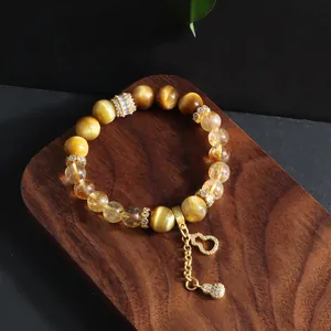Detail view of the natural yellow tower crystal and tiger eye bead bracelet charm