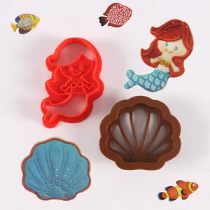Primer plano de moldes para galletas de plástico con forma de sirena y concha para repostería
