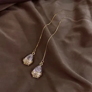 Detailansicht eleganter goldener Durchziehohrringe mit romantischen Tropfenkristallanhängern