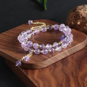 Detailed view of natural amethyst double-loop bracelet with gold spacers and tassels
