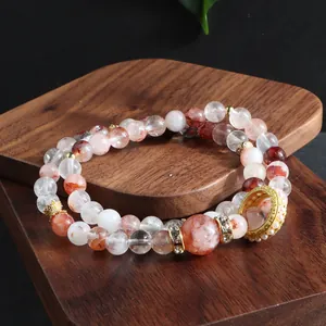 Detailed macro view of natural red phantom quartz beaded bracelet on wooden display stand