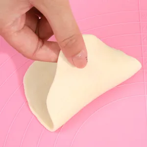 Close-up showing the non-stick surface of a pink silicone baking mat with measurements