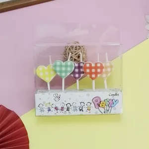Detailed view of colorful checkered heart-shaped candles in a clear party package