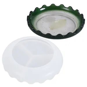 Dettaglio di uno stampo in silicone a bordi ondulati e un piatto in resina verde finito