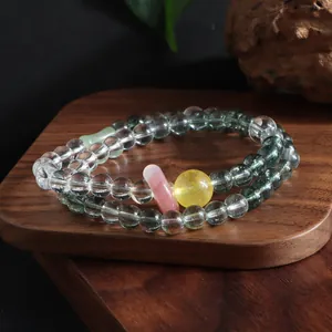 Detail view of double-layer beaded bracelet with green phantom and citrine crystals.