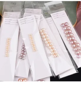 Perles d'eau douce naturelles sur cartes blanches en sachets pour bijoux DIY.
