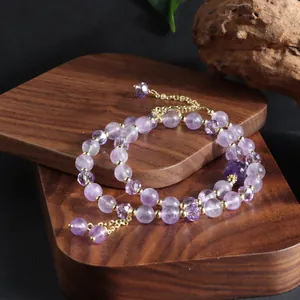 Detailed view of a natural purple amethyst double-loop bracelet featuring a golden tassel charm
