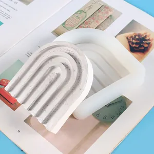 Detail view of U-shaped rainbow arch silicone mold and finished concrete decor elements.