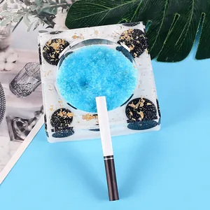 Detailed view of square resin ashtray mold with gold leaf and blue crystals decoration.