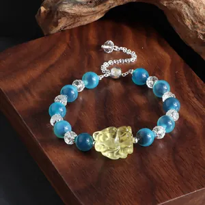 Makroansicht des Armbands aus blauem Achat und Kristall mit gelbem Katzenanhänger