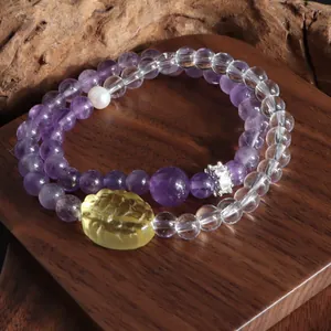 Gros plan du bracelet double rang en améthyste et quartz clair avec pendentif lion