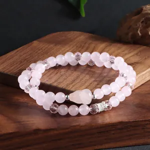 Gros plan détaillé d'un bracelet double rang en quartz rose naturel avec breloque renard
