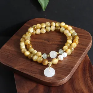 Exquisite Nahaufnahme eines zweischichtigen Armbands aus goldenem Tigerauge mit Jadeanhänger