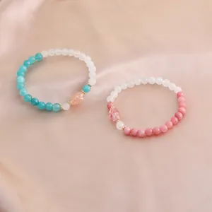 Detailansicht von Naturkristall-Armbändern mit Edelsteinen auf Satin-Hintergrund
