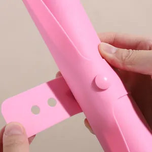 Close-up of pink silicone baking mat featuring a convenient strap and button for storage.