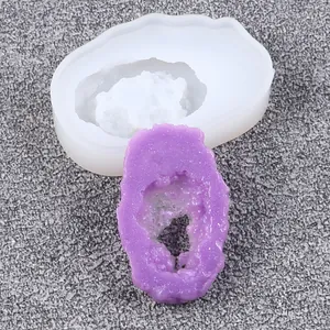 Detailansicht der Silikonform und eines lila fertigen Harzkristallclusters Geode