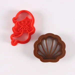 Detalle de moldes de plástico para galletas con forma de sirena y concha de mar