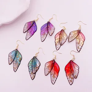 Detailed view of colorful gradient cicada wing earrings with gold foil flakes