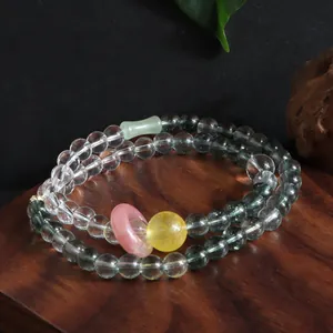 Close-up of double-loop crystal bracelet with green phantom and yellow quartz beads.