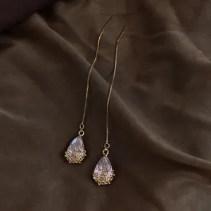 Detailansicht eleganter Wassertropfen-Zirkonia-Durchzieher-Ohrringe mit Goldblumenbasis