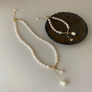 Detailansicht eines Sets aus Süßwasserperlen-Halskette und Armband mit Muschelblumen-Anhänger.