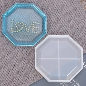 Detalle de molde de silicona octogonal y posavasos de resina azul con diseño de perlas love