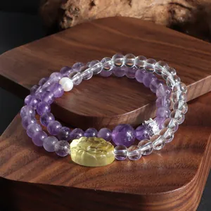 Détail du bracelet double en améthyste et quartz clair avec breloque de lion.