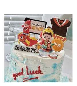 Detalle de adornos para tarta de graduación con peces koi y figuras de eruditos.